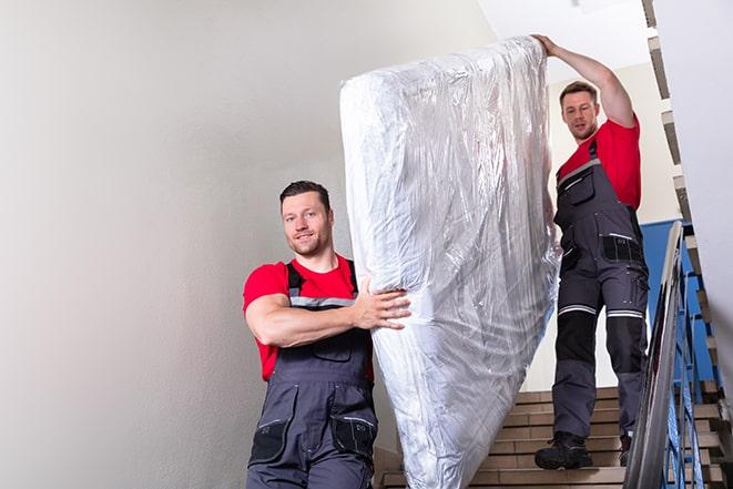 heavy lifting of a box spring during home renovation in Ashley