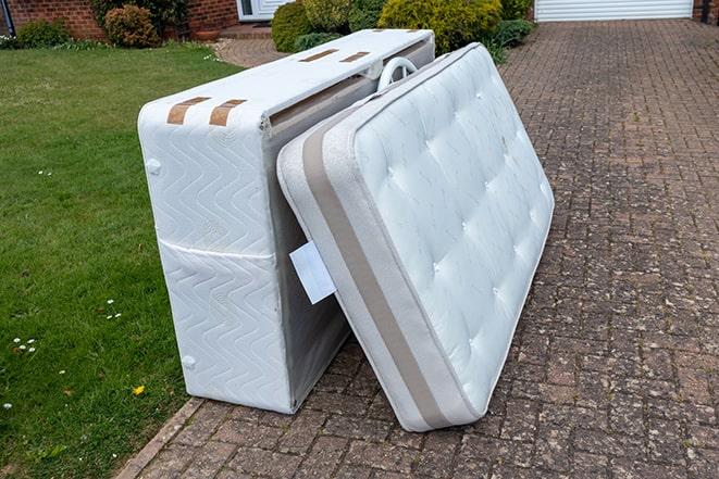 workers carrying a mattress out of a bedroom